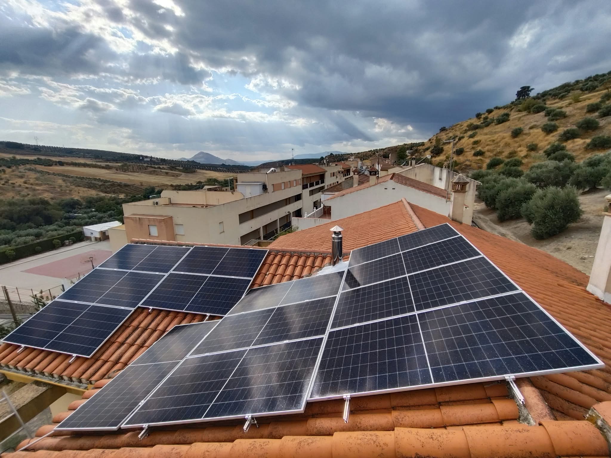 Paneles solares distribuidos en varios faldones de un tejado de teja